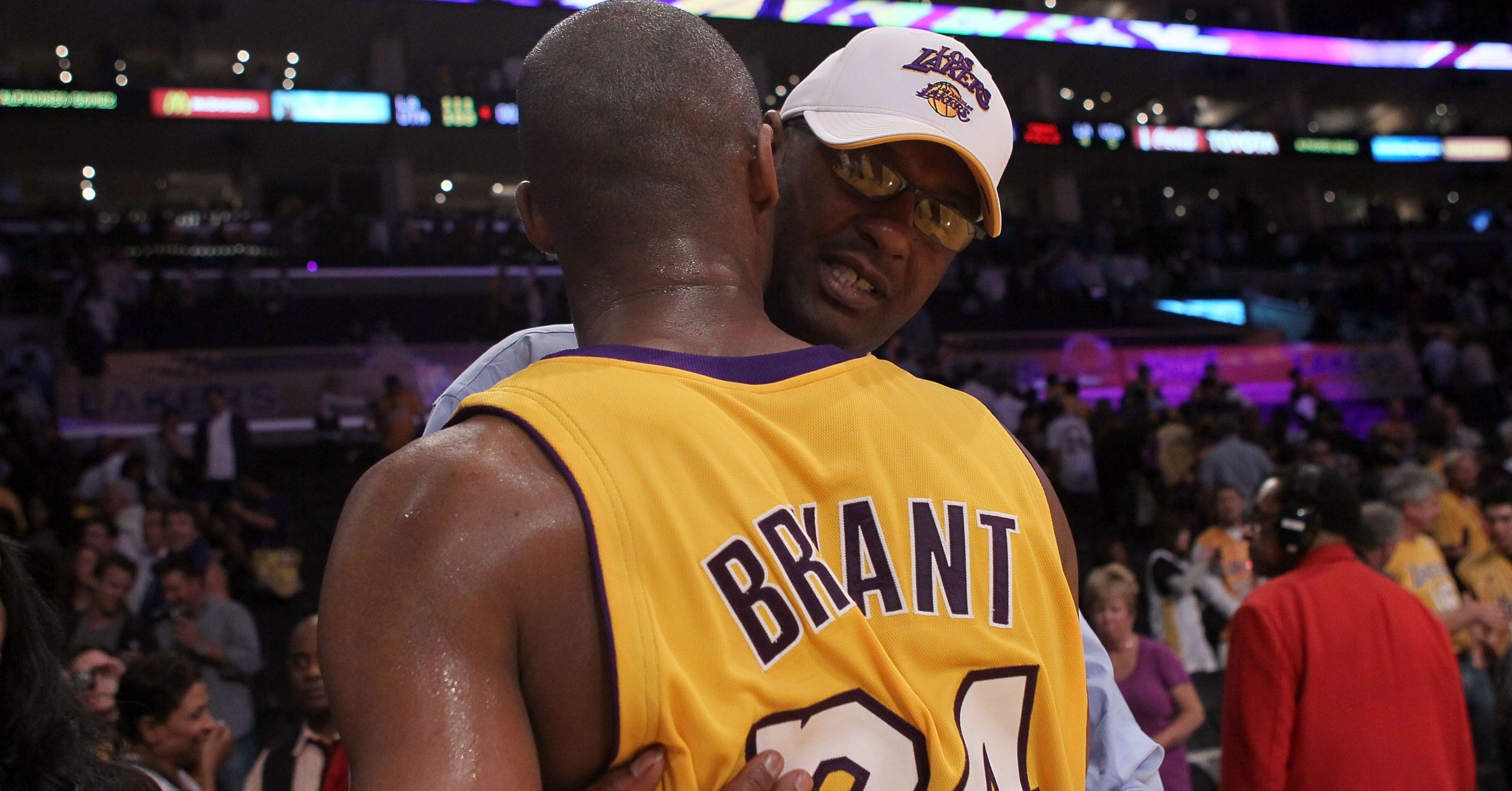 Joe Bryant hugging his son Kobe Bryant during a game