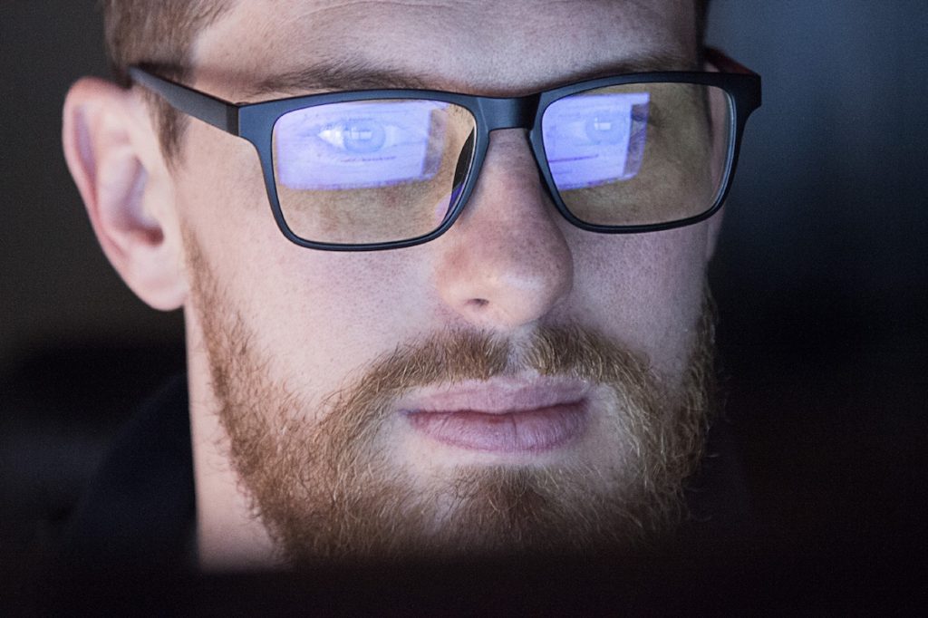 A young man wearing blue light blocking glasses