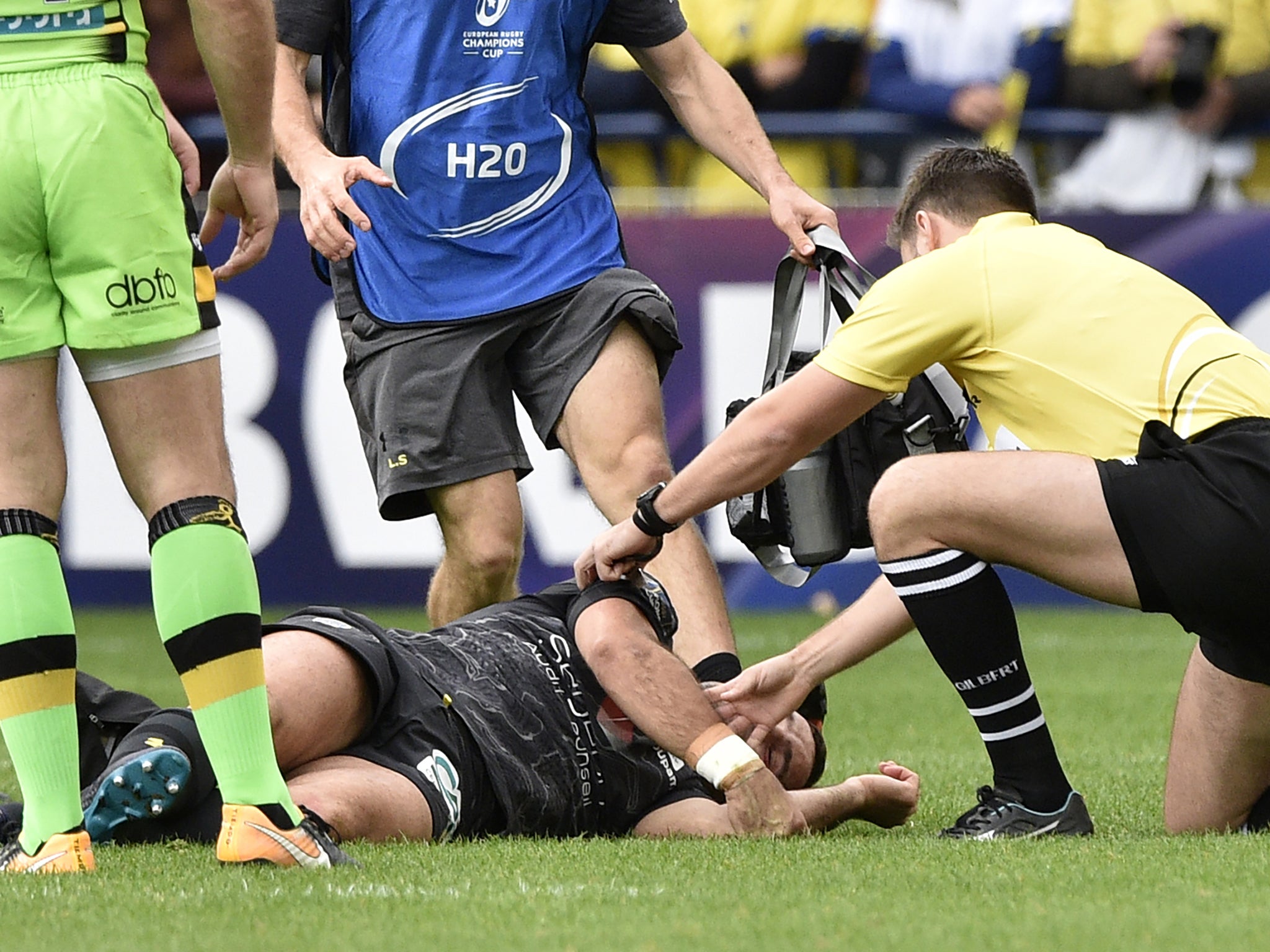 A rugby player laying on the field after an injury