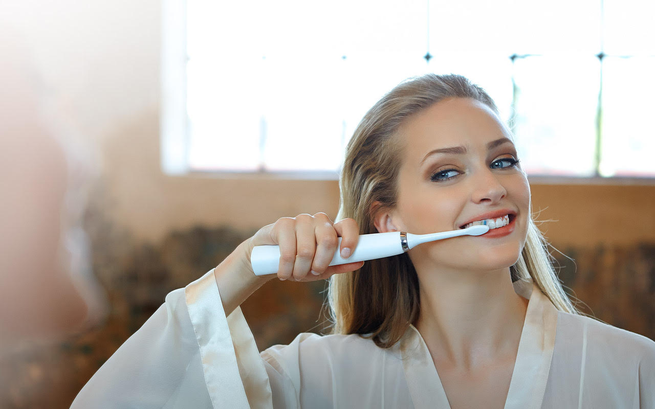 Woman using an electric toothbrush